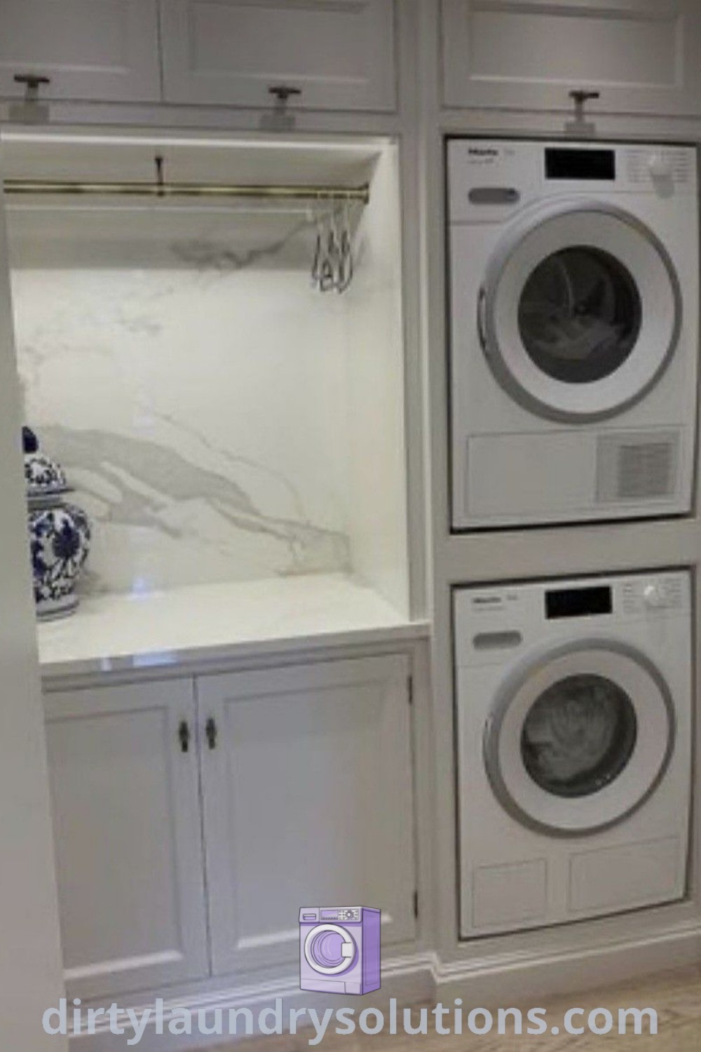 A white laundry room with a stacked washer and dryer, marble backsplash, and slide-out cabinets, optimized for small spaces. Explore stylish and functional laundry room ideas at dirtylaundrysolutions.com.