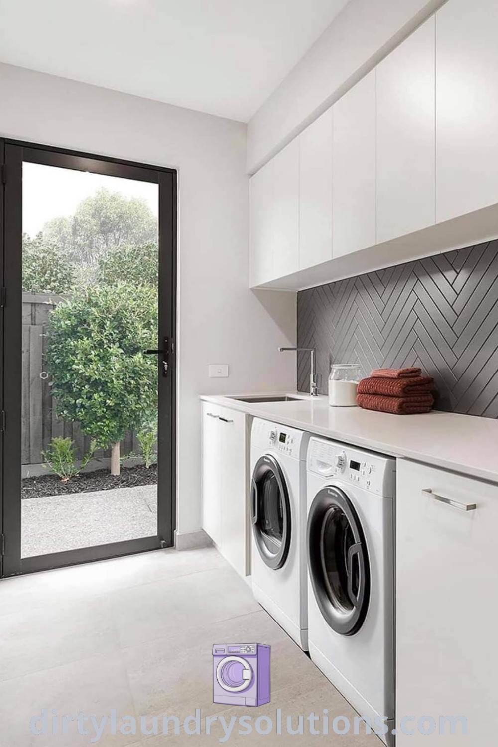 A white laundry room with a washer and dryer, featuring an open door to the outside, designed for narrow spaces. Discover inspiring ideas for your home and organization solutions at dirtylaundrysolutions.com.