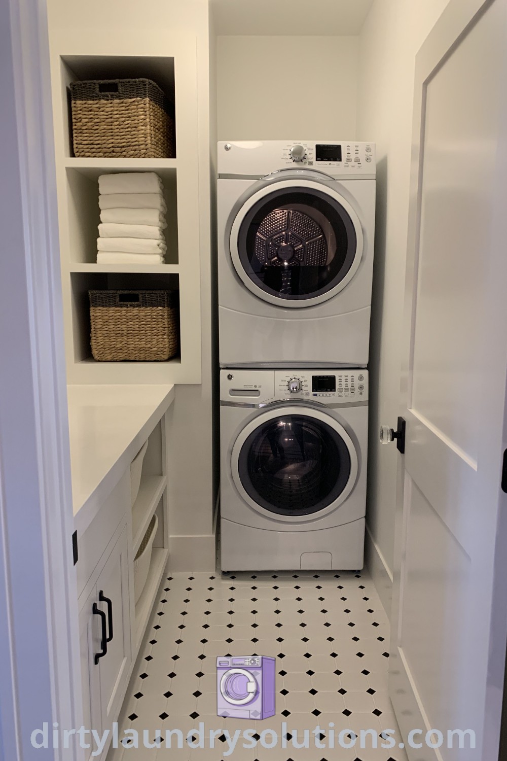 A washer and dryer in a small room with black and white flooring, featuring stylish laundry room storage cabinets and clever organization solutions. Discover inspiring laundry room ideas and maximize your space at dirtylaundrysolutions.com.