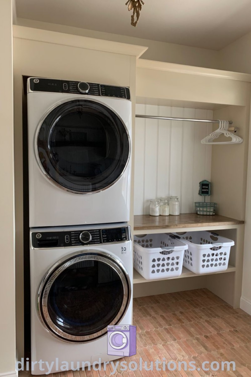 A washer and dryer adjacent to each other in a cozy laundry room with wooden floors, decorated with inspiring laundry quotes, showcasing organization ideas and maximizing small spaces. Discover unique laundry room makeover ideas at dirtylaundrysolutions.com.