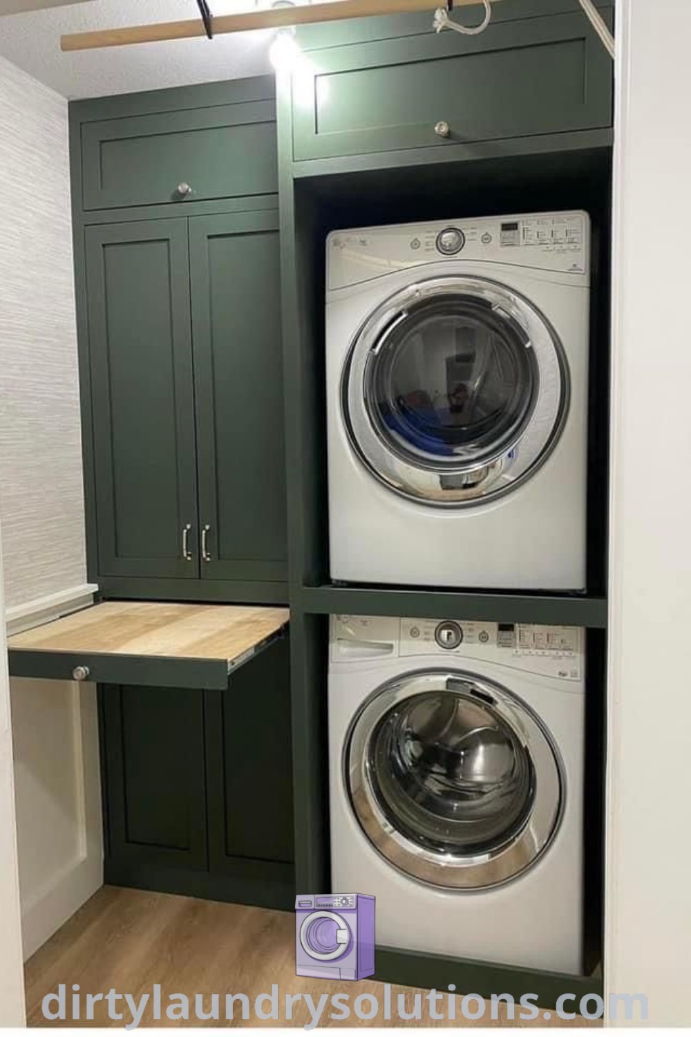 A cozy laundry room featuring a stacked washer and dryer with green cupboards, complemented by a convenient laundry folding table. Discover inspiring design ideas and organization solutions for small spaces at dirtylaundrysolutions.com.