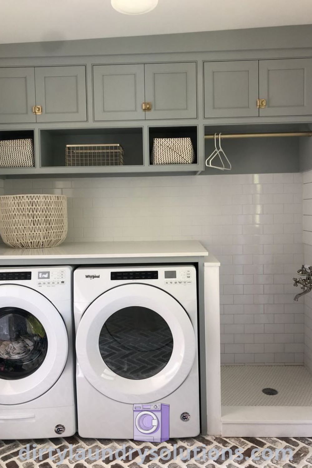 A laundry room showcasing a washer and dryer with a built-in dog bath, gray cupboards on the wall, and organized pet area solutions. Explore unique laundry room ideas for your home at dirtylaundrysolutions.com.