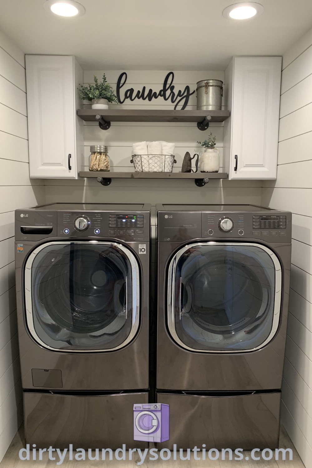 A laundry room featuring a dark washing machine and gray washer and dryer paired with white cabinets on the wall, illustrating cozy ideas and inspiring organization solutions for your space. Discover more unique ideas for your laundry room at dirtylaundrysolutions.com.