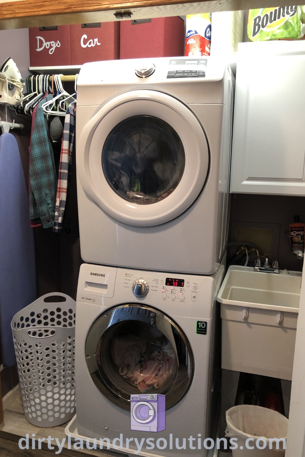 A stacked washer and dryer in a cozy laundry room, designed for small spaces, featuring a slop sink and organizational elements. Discover more inspiring laundry room solutions at dirtylaundrysolutions.com.