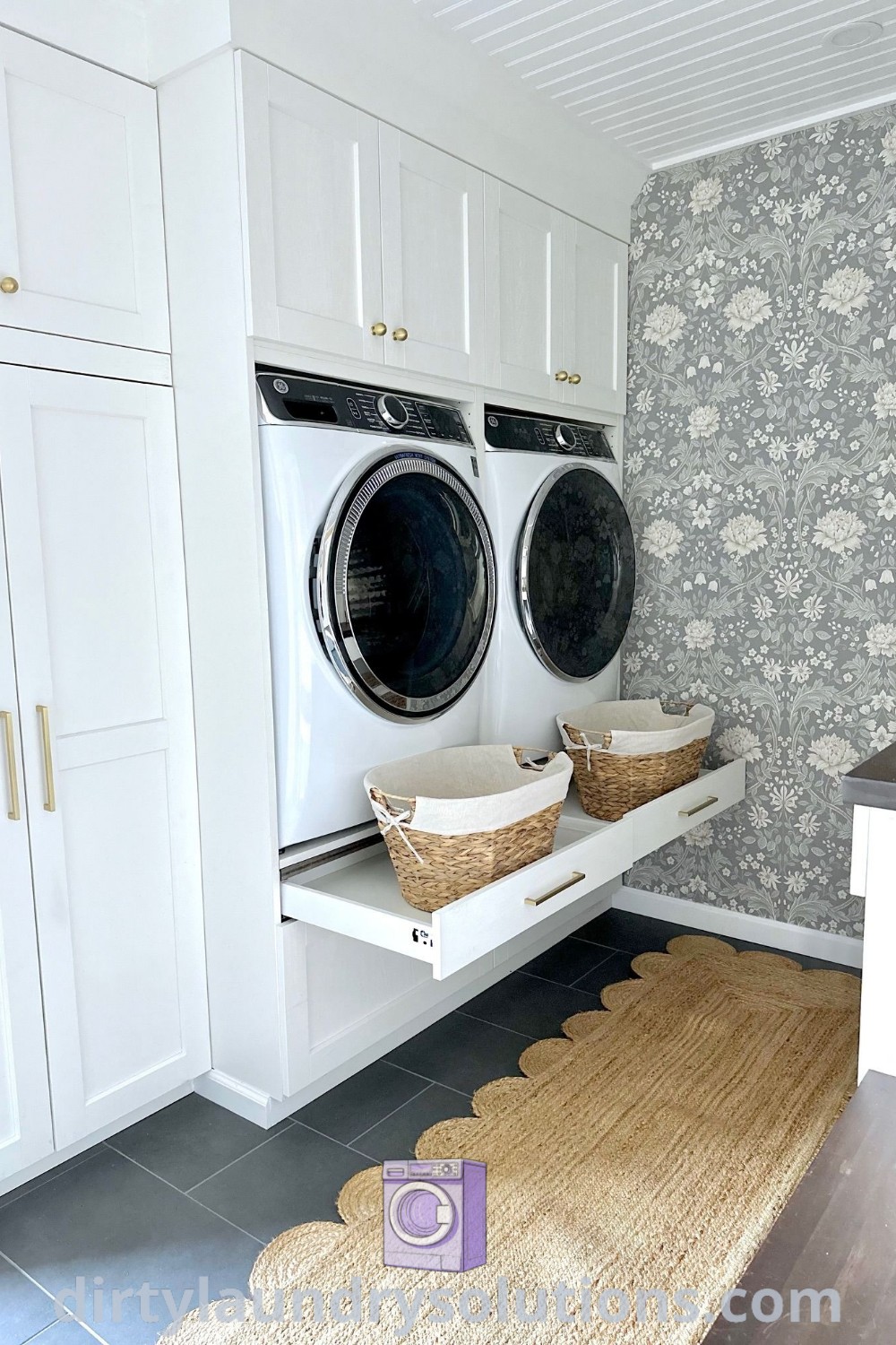 A bright laundry room featuring a white washer and dryer surrounded by floral wallpaper, offering a cozy home aesthetic. Discover inspiring ideas and organization solutions for your home at dirtylaundrysolutions.com.