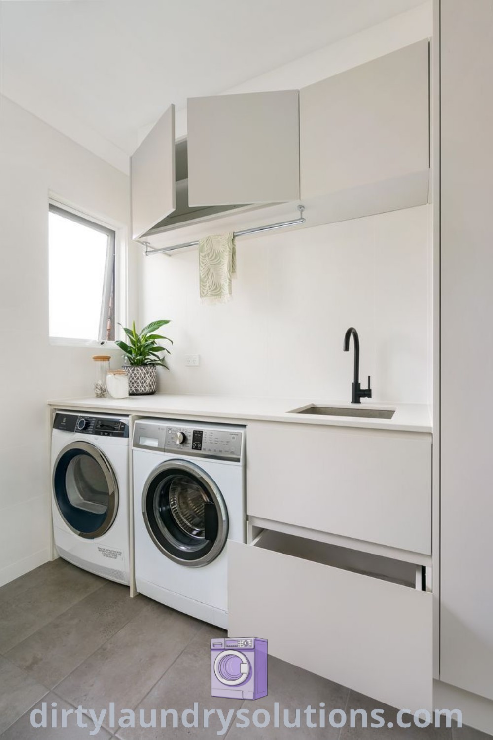 A washer and dryer in a white kitchen, complemented by a stainless steel faucet, ideal for laundry renovation ideas and organization laundry room solutions at dirtylaundrysolutions.com.