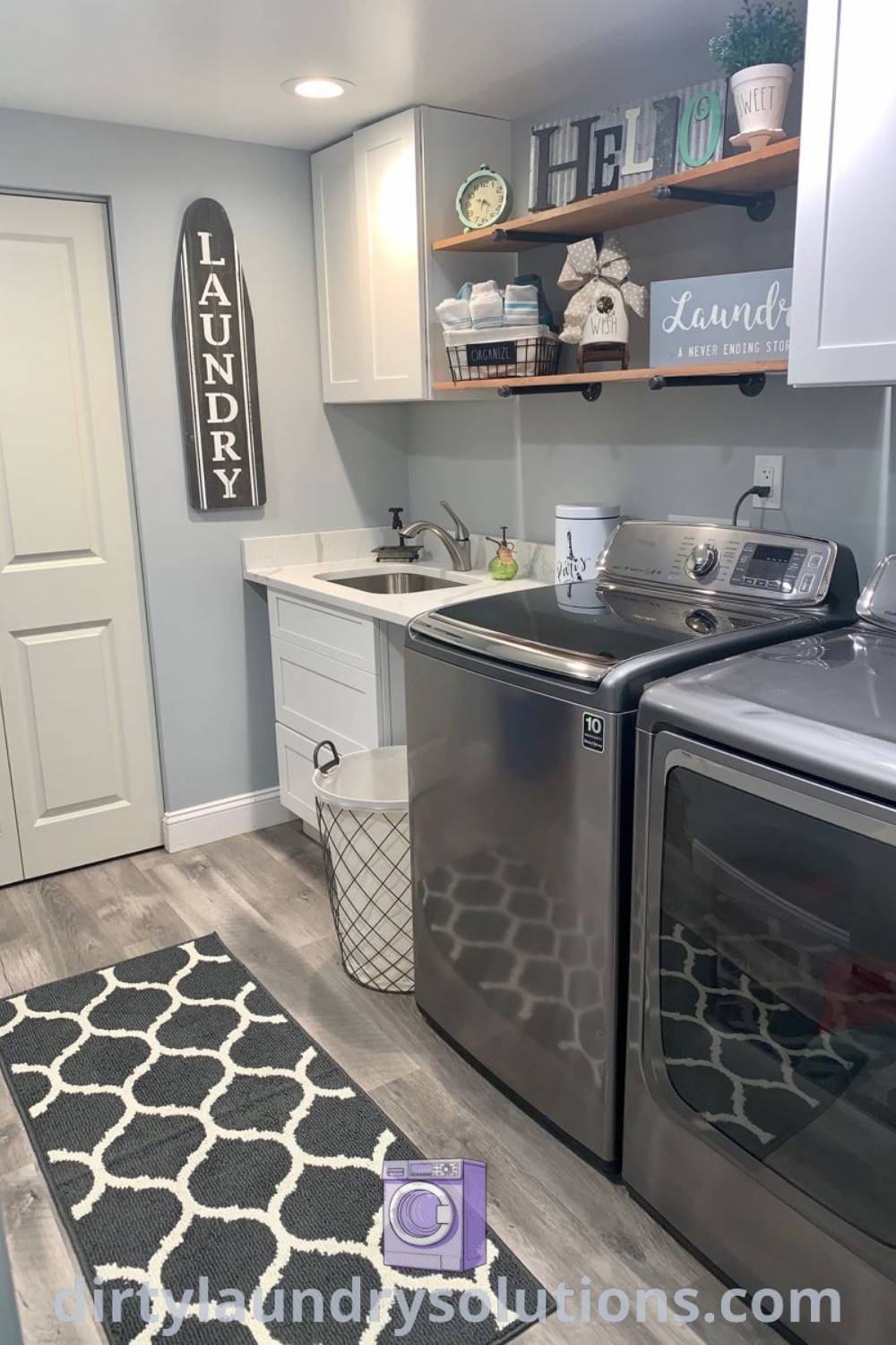 A gray washer and dryer in a cozy laundry room next to white cabinets, showcasing stylish laundry room ideas for homes. Discover inspiring design ideas and solutions for optimizing small spaces at dirtylaundrysolutions.com.