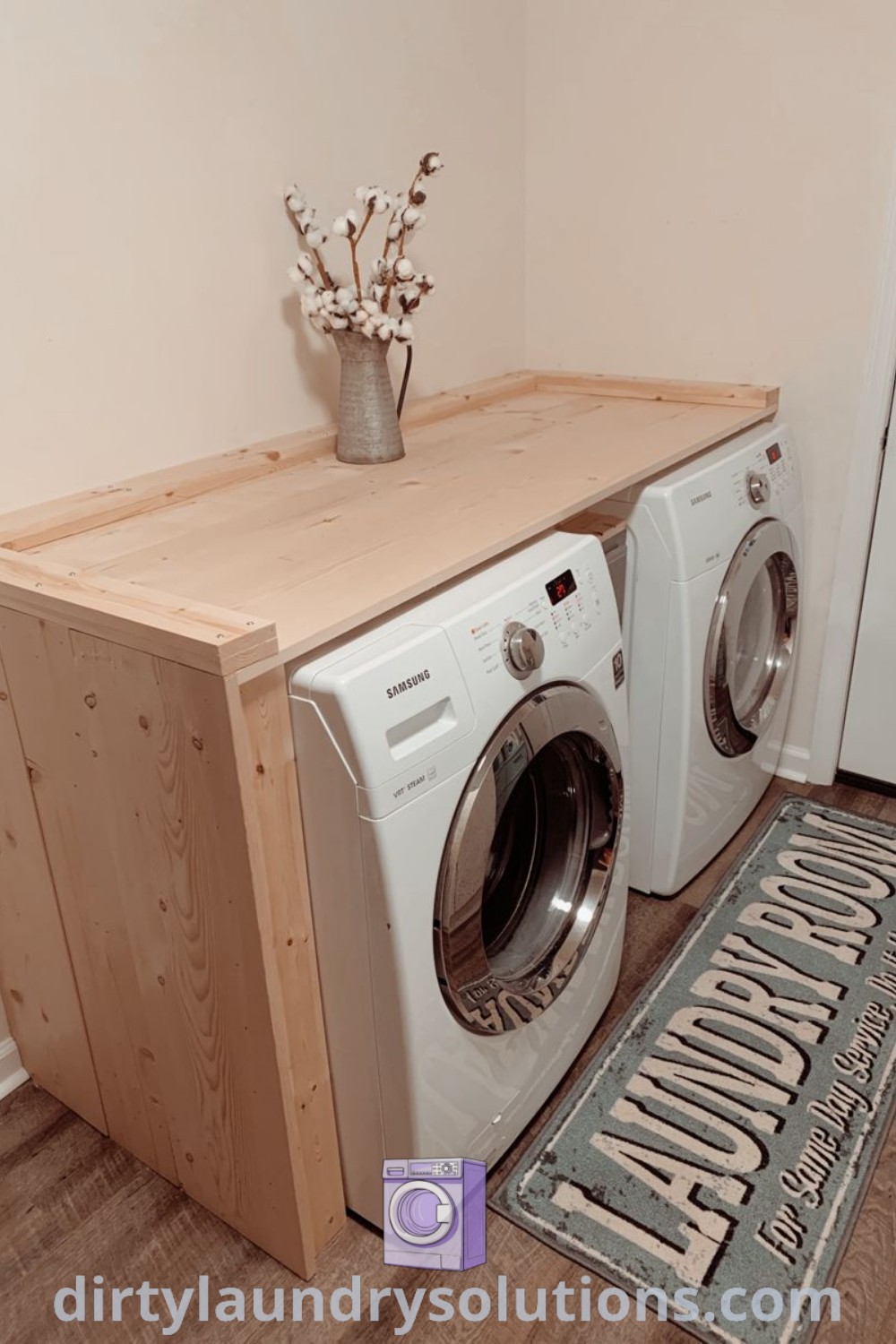 A washer and dryer side by side on a wood platform with a wood top, featuring shelving above for storage. Discover stylish solutions and organization ideas for your laundry space at dirtylaundrysolutions.com.