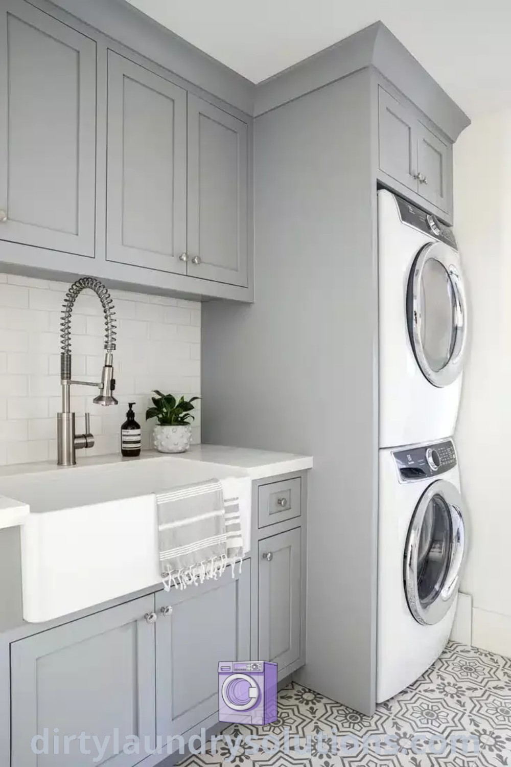A small contemporary laundry room featuring a washer and dryer in front of metro white subway tiles, showcasing laundry storage ideas and inspiration for cozy home organization. For more creative solutions, visit dirtylaundrysolutions.com.