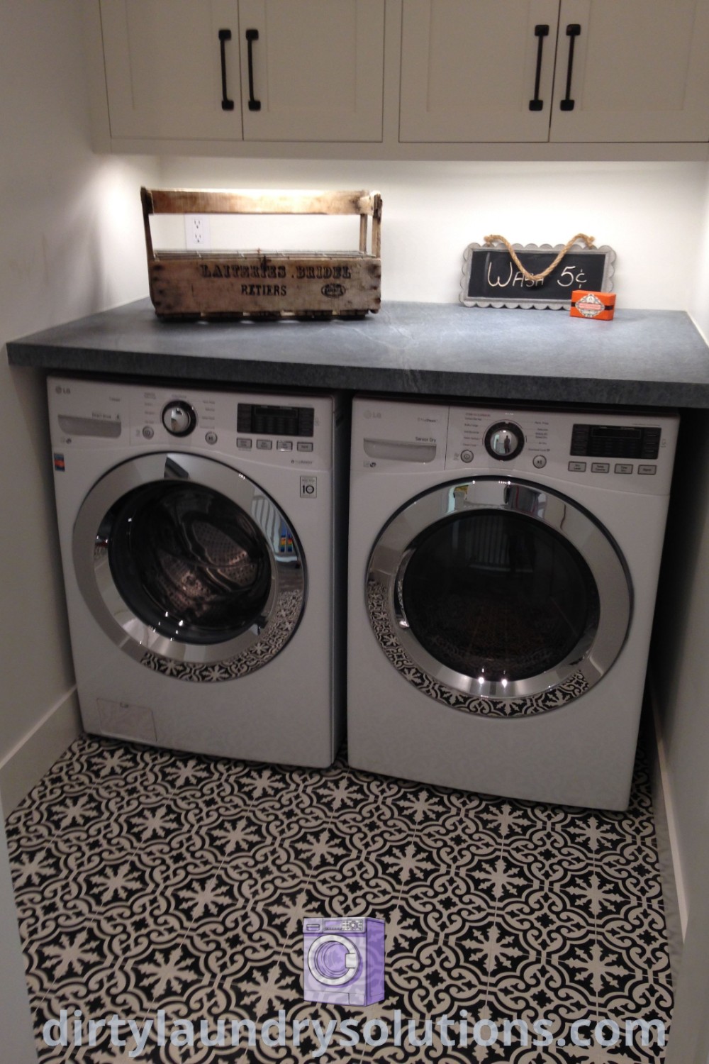 A cozy laundry room with a washer and dryer in a small space featuring black and white flooring, showcasing laundry room organization ideas and inspirations. Discover more unique ideas for your home at dirtylaundrysolutions.com.