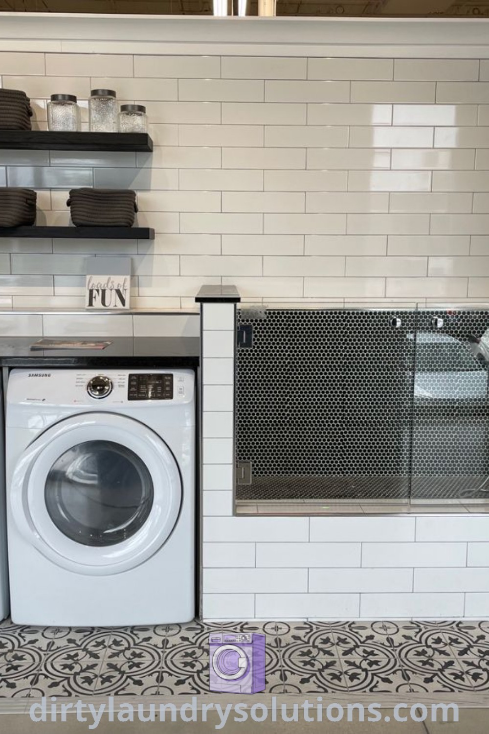 A laundry pet room with a washer and dryer, featuring a dog washing station and a shower utility room with white tile flooring, providing a cozy and functional space for pet care and laundry tasks. Discover more unique ideas and solutions at dirtylaundrysolutions.com.