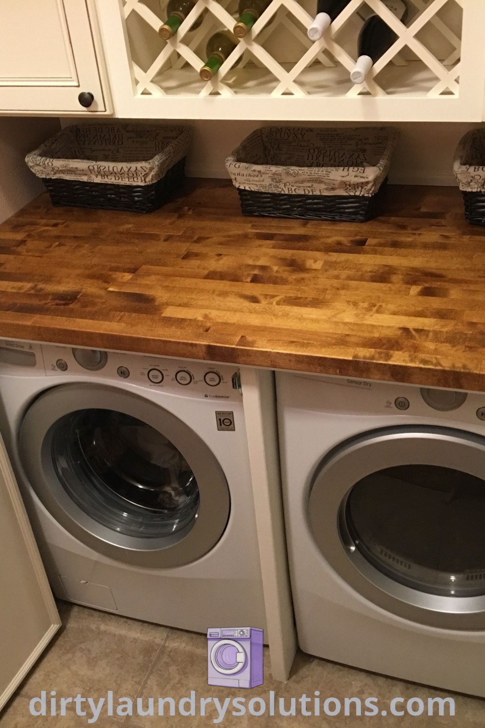 A cozy laundry room featuring a washer and dryer next to a hidden folding table, surrounded by white cabinets for organization. Discover solutions and inspirations for small laundry room makeovers at dirtylaundrysolutions.com.