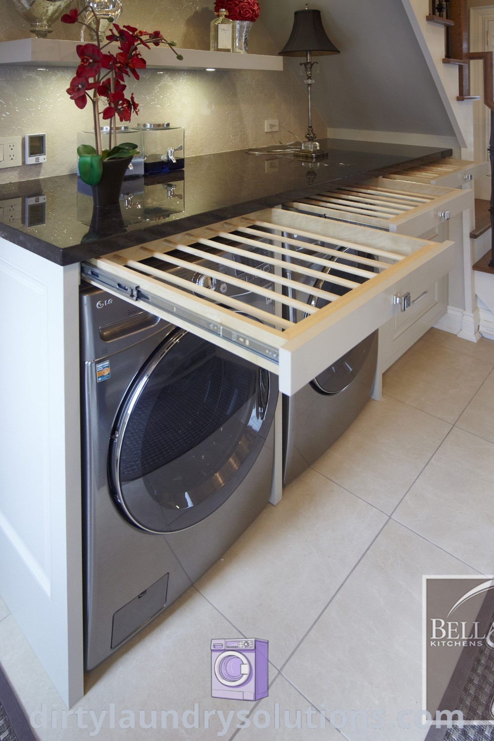 A stylish laundry room showcasing a washer and dryer with stairs leading to a second-floor home office. This design illustrates modern laundry room layouts and cozy aesthetics, ideal for small home offices. Find more organization ideas at dirtylaundrysolutions.com.