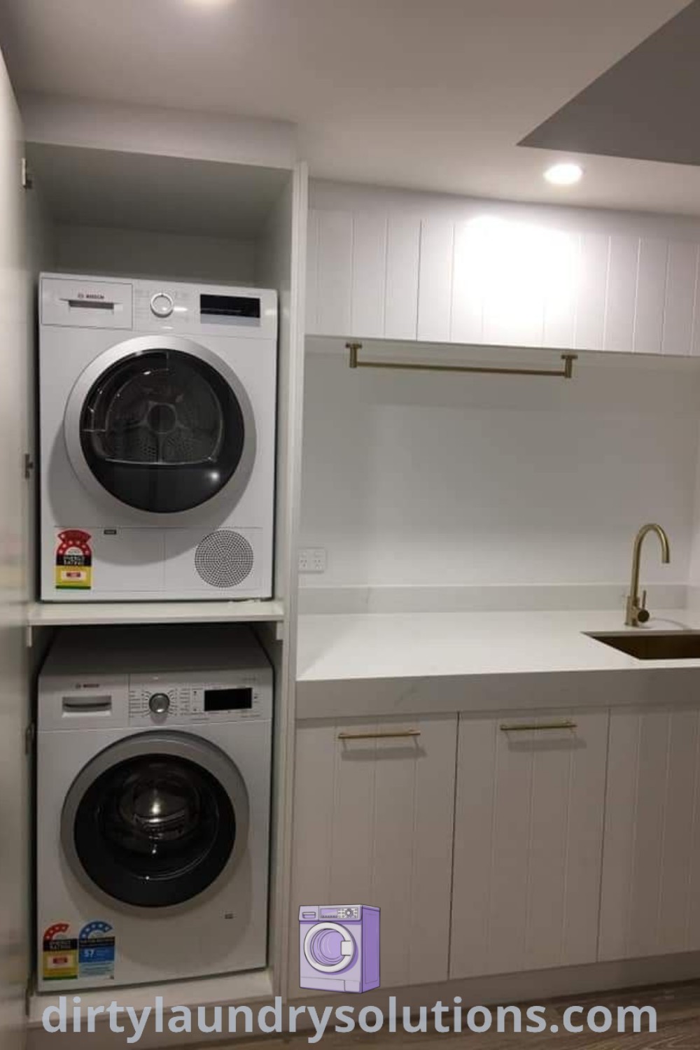 A small laundry alcove with a washer and dryer, complemented by white cabinets on the wall, providing an organized and stylish space. Discover innovative laundry room layouts and design ideas at dirtylaundrysolutions.com.