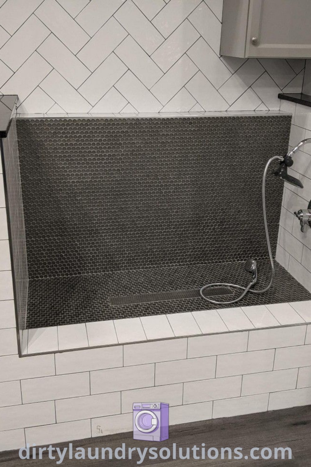 A cozy laundry room with a washer and dryer surrounded by white tiles, showcasing a dog bathing station and utility extension. Discover inspiring ideas for your home at dirtylaundrysolutions.com.