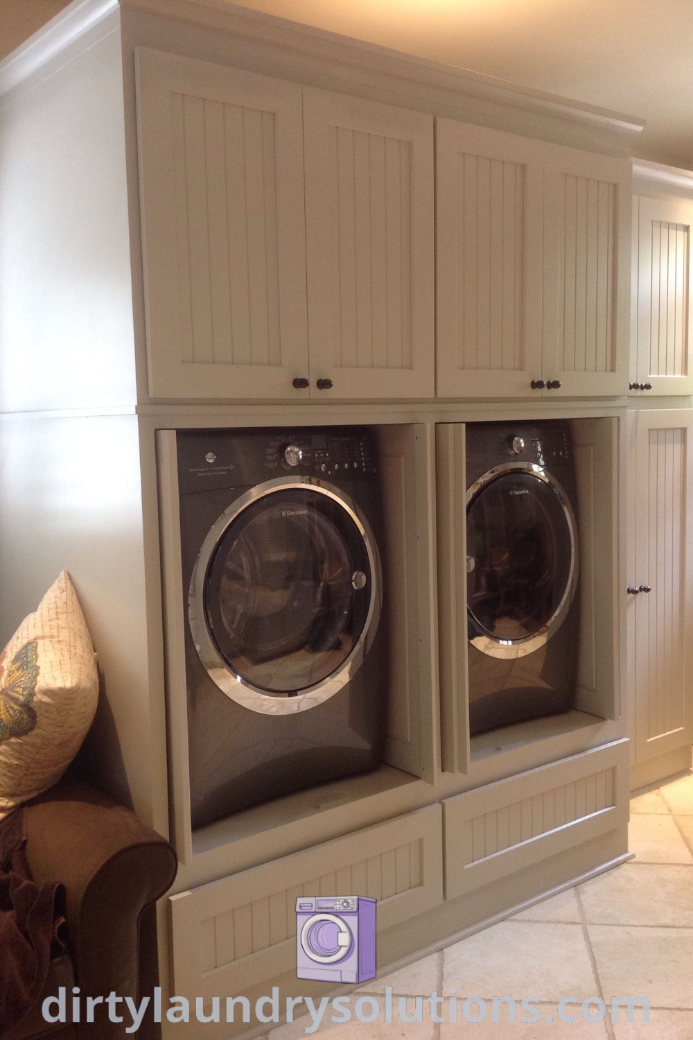 A washer and dryer hidden behind cabinet doors in a stylish laundry room, showcasing effective space-saving solutions and organization ideas for homes. Discover more about cozy laundry room designs at dirtylaundrysolutions.com.