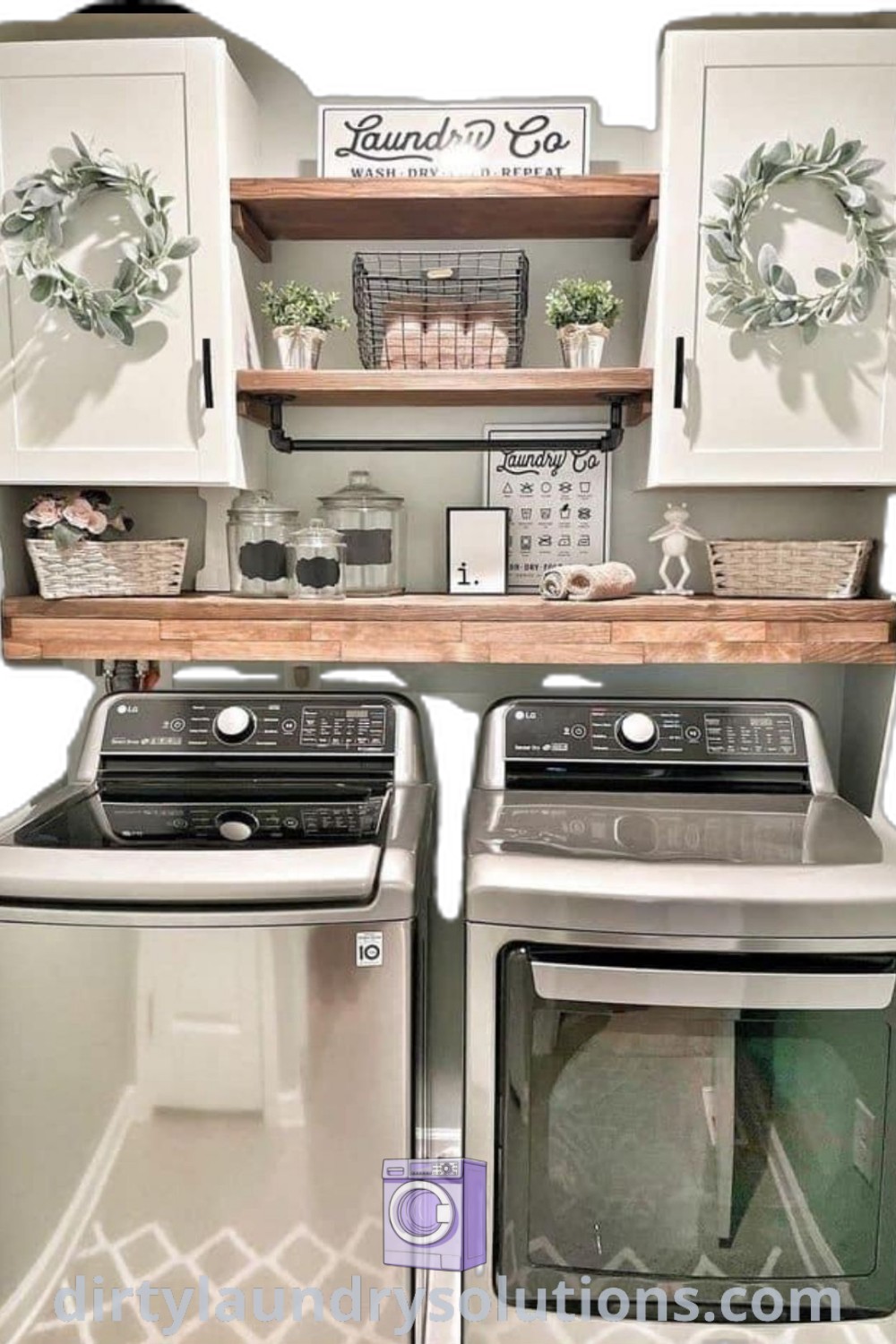 A washer and dryer sitting next to wood shelves in a cozy laundry room with white cabinets, showcasing small laundry room ideas for a stylish and organized space. Discover more designs and solutions for your home at dirtylaundrysolutions.com.