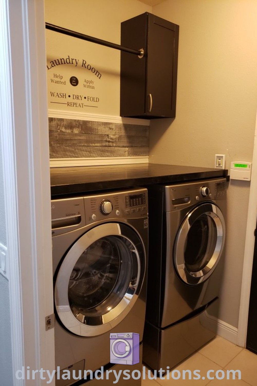 A washer and dryer in a small room with the door open, showcasing a cozy laundry room setup with modern decor. Discover laundry room renovation ideas and solutions for small spaces at dirtylaundrysolutions.com.