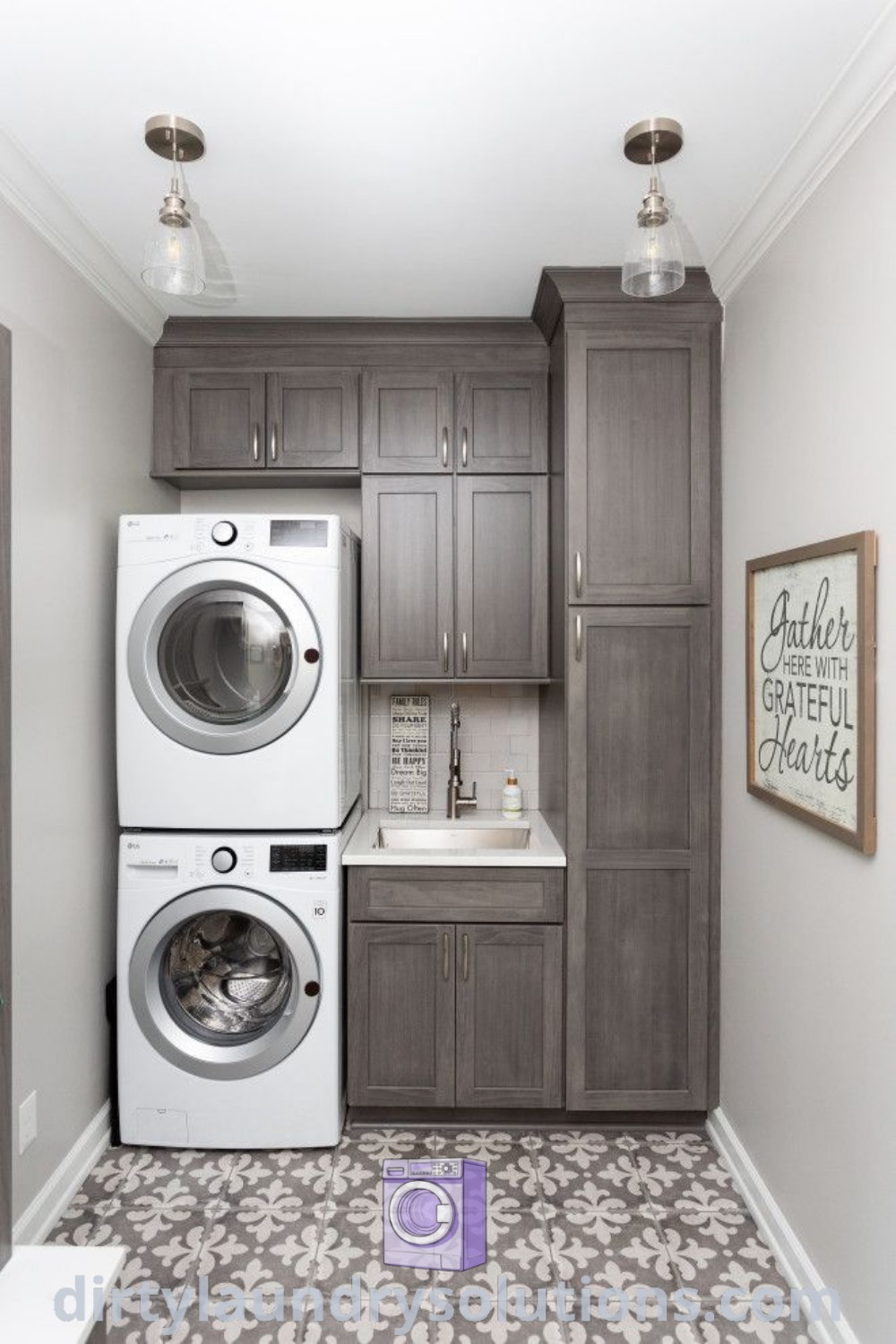A cozy laundry room featuring a washer and dryer, gray cabinets, white countertops, and patterned flooring, offering functional organization and aesthetic appeal for busy homes. Find inspiring ideas and solutions at dirtylaundrysolutions.com.