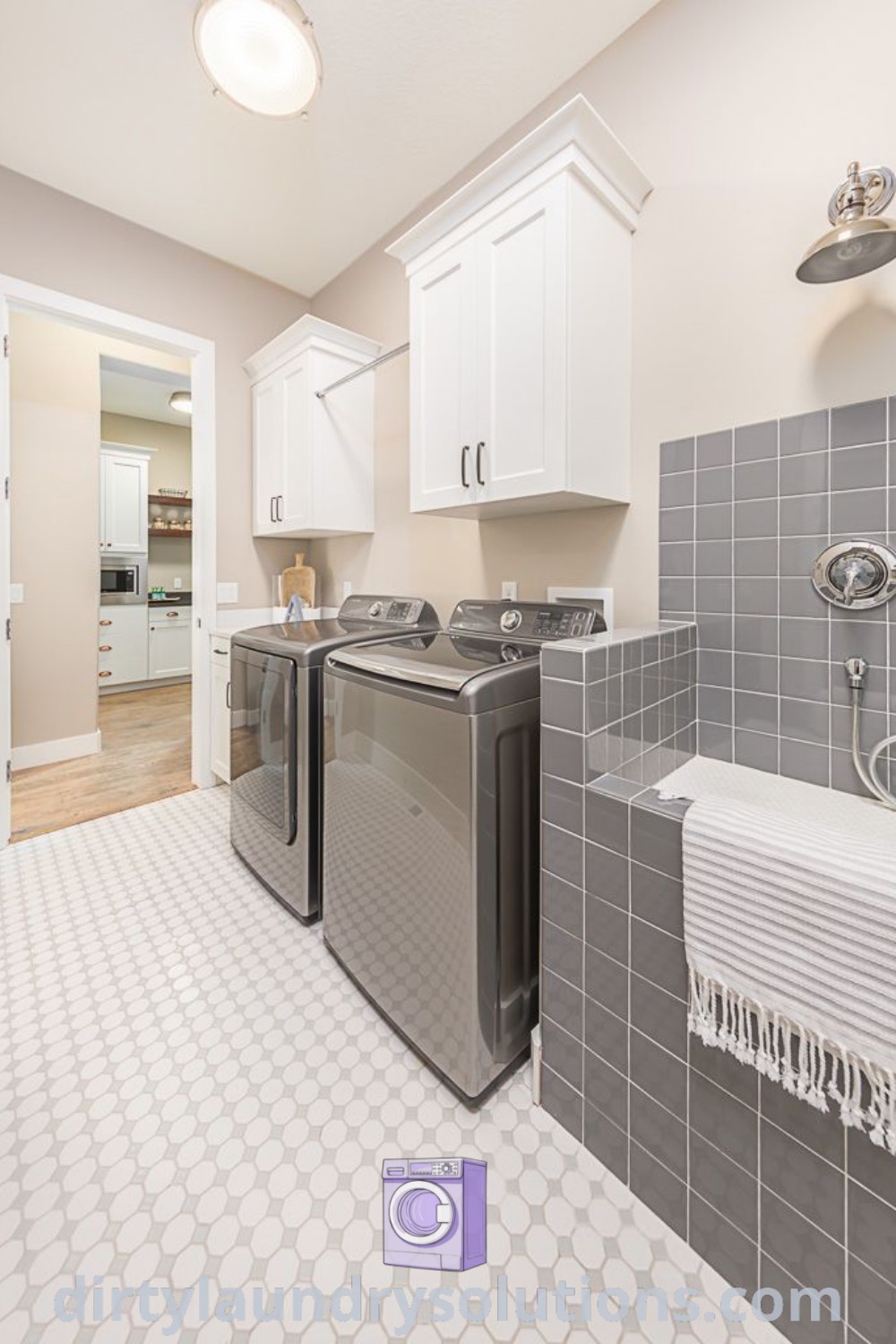 A stylish laundry room with a washer and dryer, featuring a dedicated dog washing station ideal for busy homes and cozy living. Explore functional design ideas and laundry room solutions at dirtylaundrysolutions.com.