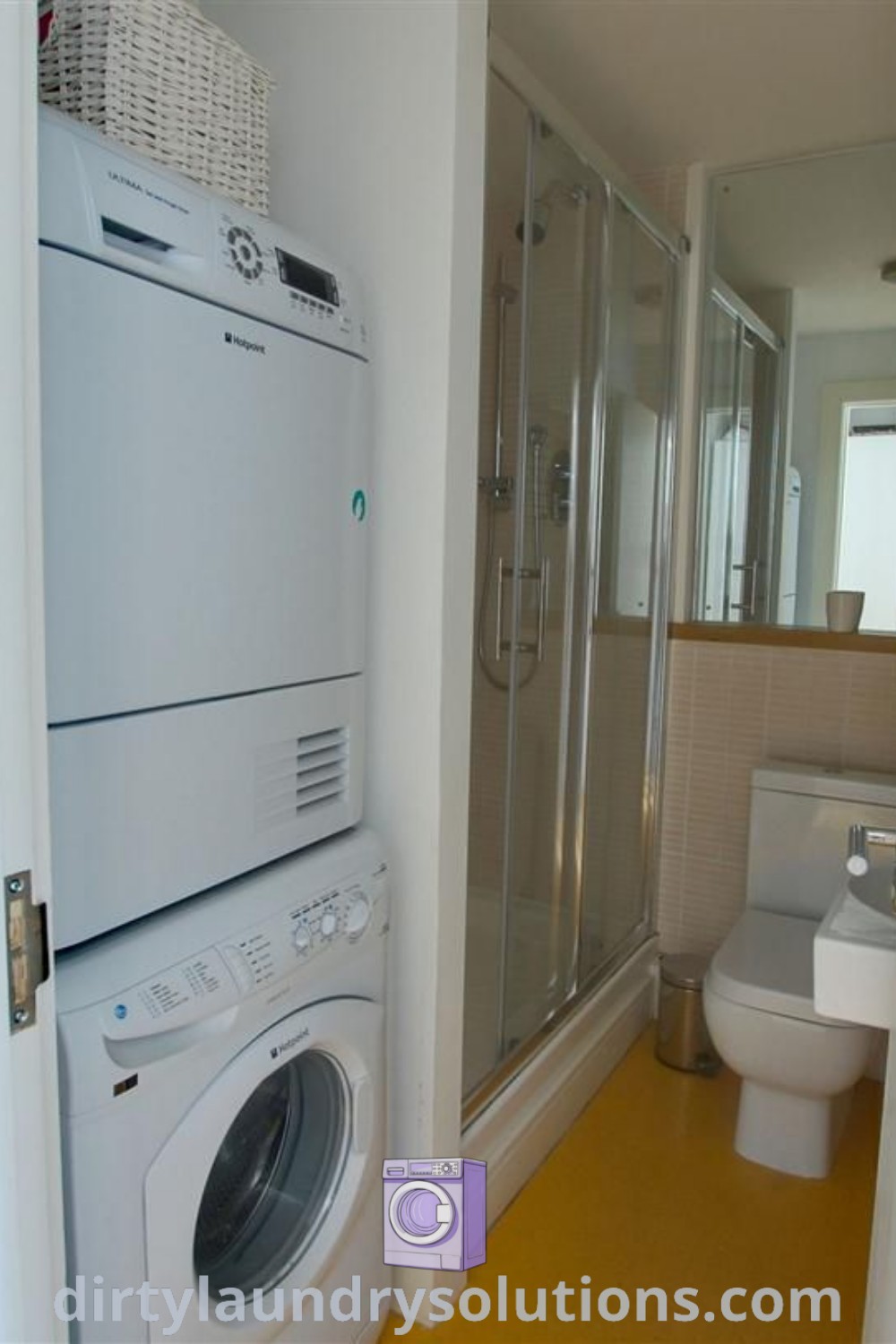 A bathroom with a washer and dryer beside each other on a yellow floor, demonstrating smart design ideas for a utility room. Discover inspiring solutions for your home at dirtylaundrysolutions.com.