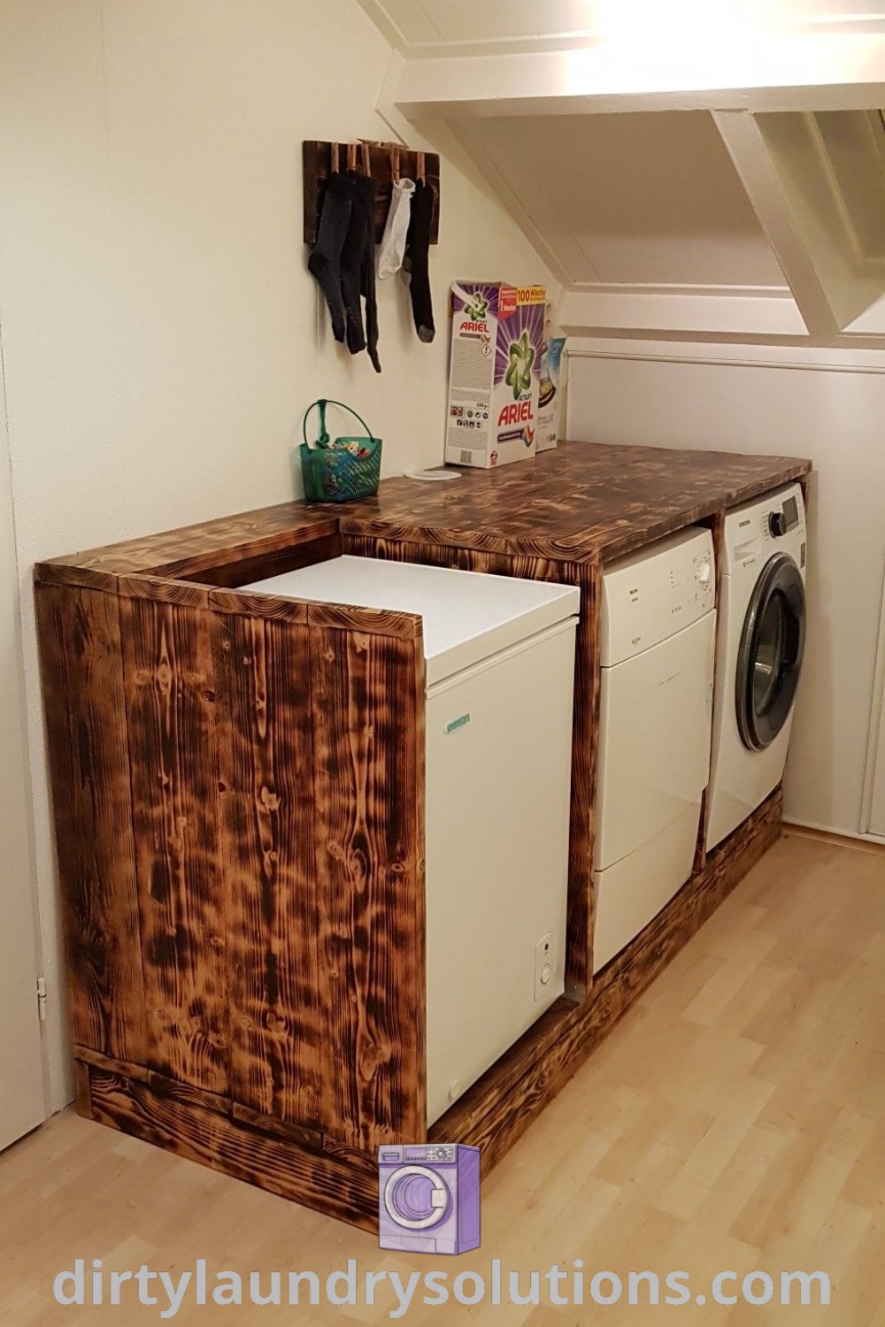 A washer and dryer in an outdoor setting with wood flooring, highlighting outdoor washing machine cabinet options and DIY laundry cabinet ideas. Discover organization solutions and cozy aesthetic inspirations at dirtylaundrysolutions.com.