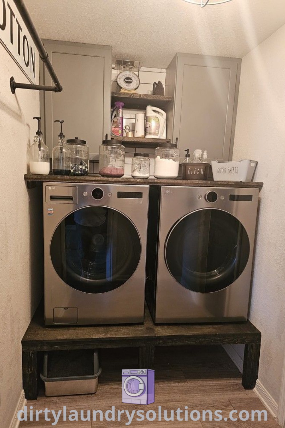 Two washers sitting next to each other in a room with a sign on the wall, showcasing a cozy and functional setup featuring laundry room pedestals for washer and dryer at dirtylaundrysolutions.com.