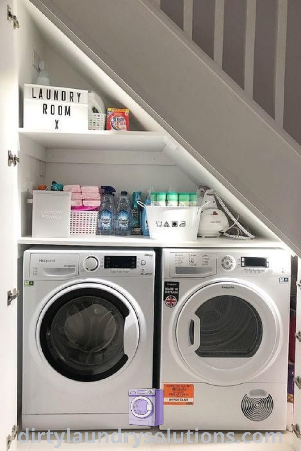 A cozy laundry room featuring a washer and dryer under the stairs with white walls, showcasing impressive organization ideas for small spaces. Discover more stylish laundry room inspirations at dirtylaundrysolutions.com.