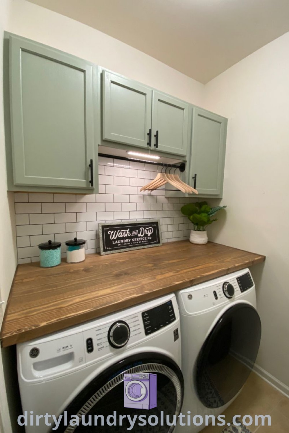A cozy laundry room featuring a washer and dryer with sage green cabinets, designed for small spaces. Explore laundry room ideas including earthy tones and stylish storage solutions at dirtylaundrysolutions.com.
