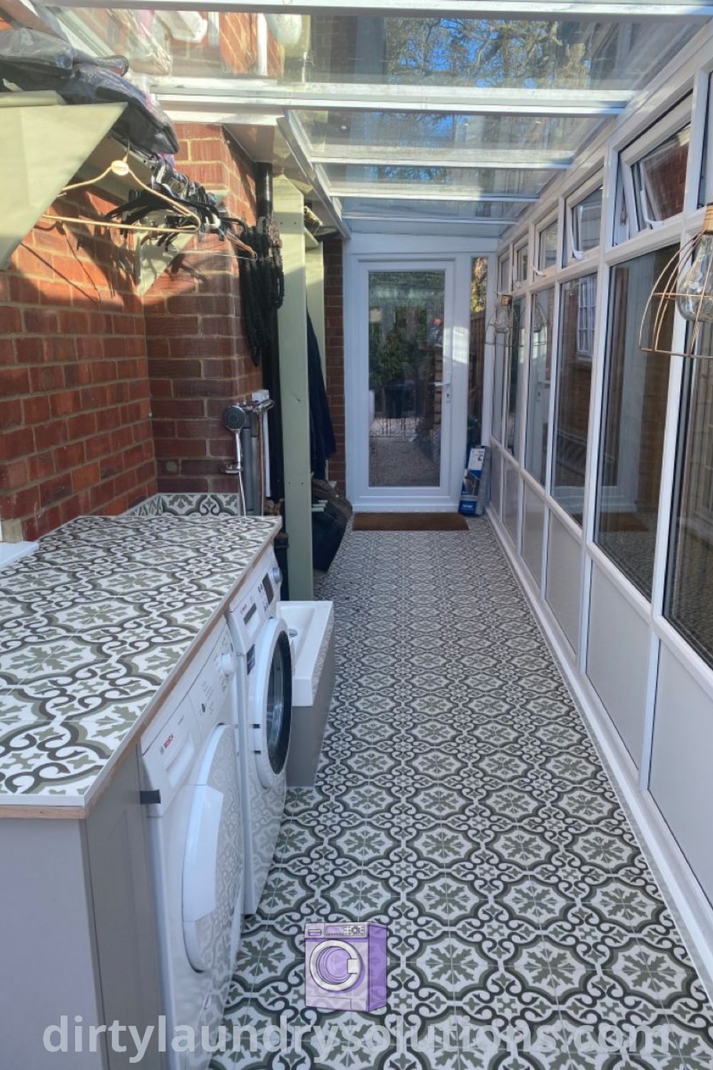 A utility room with tiled flooring, a white washer and dryer, demonstrating practical design ideas for a laundry space including laundry outdoor backyards and sunroom utility room concepts. For more inspirations, visit dirtylaundrysolutions.com.
