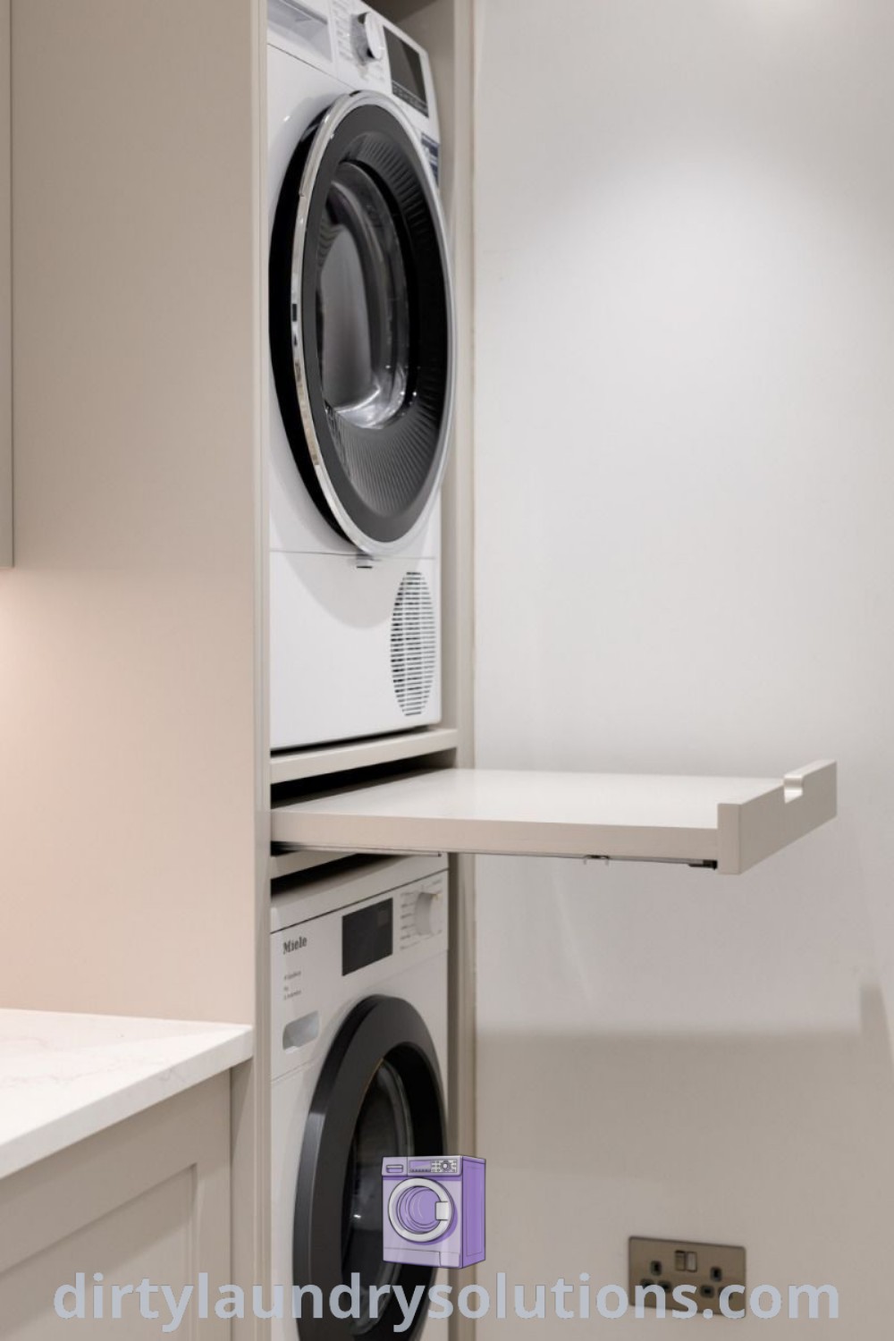 A stacked washer and dryer in a small kitchen room with white cabinets, complemented by a convenient pull-out laundry shelf. Discover inspiring ideas and organization solutions for small spaces at dirtylaundrysolutions.com.