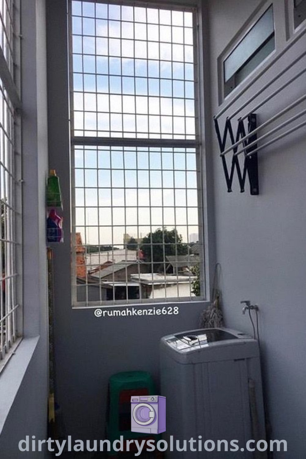 An outdoor laundry area with a small window overlooking an industrial area, showcasing a grill wall design. This cozy setup combines practical solutions for busy homes and inspiring ideas for small spaces, promoting organization and functionality, while found at dirtylaundrysolutions.com.