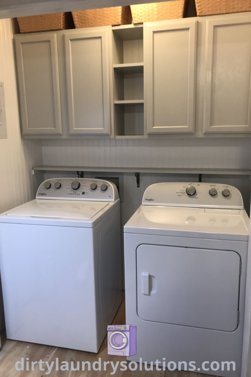 A small laundry room featuring a white washer and dryer, white cabinets on the walls, and organized shelves between cabinets for effective storage solutions. Discover more inspiring ideas and organization tips for your home at dirtylaundrysolutions.com.