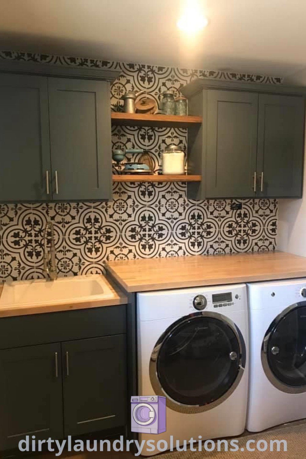 A small laundry room featuring a gray washer and dryer, dark cabinets, and sage green cabinetry, showcasing stylish organization ideas and decor. Explore solutions to freshen up your space at dirtylaundrysolutions.com.