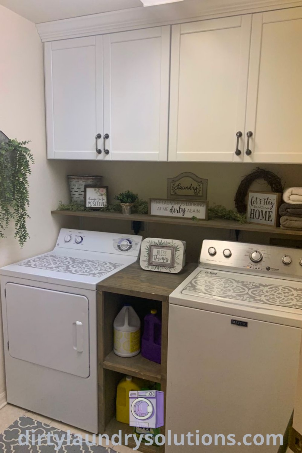 A cozy small laundry room featuring a top loader washer and dryer with white cupboards, exemplifying stylish organization ideas and inviting decor. Discover unique laundry room designs and solutions at dirtylaundrysolutions.com.